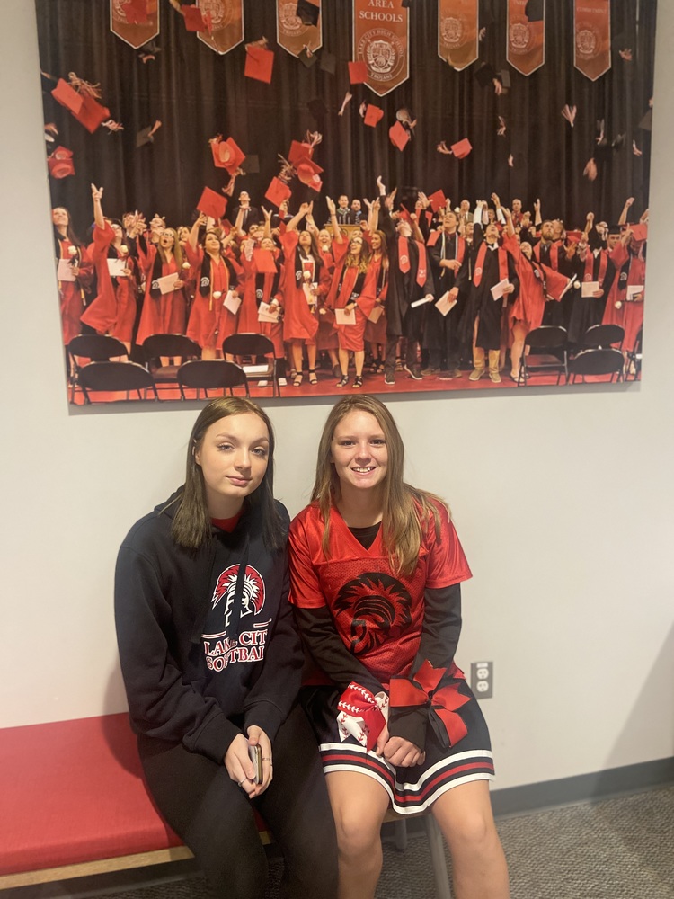 Students sitting in front of graduation photo